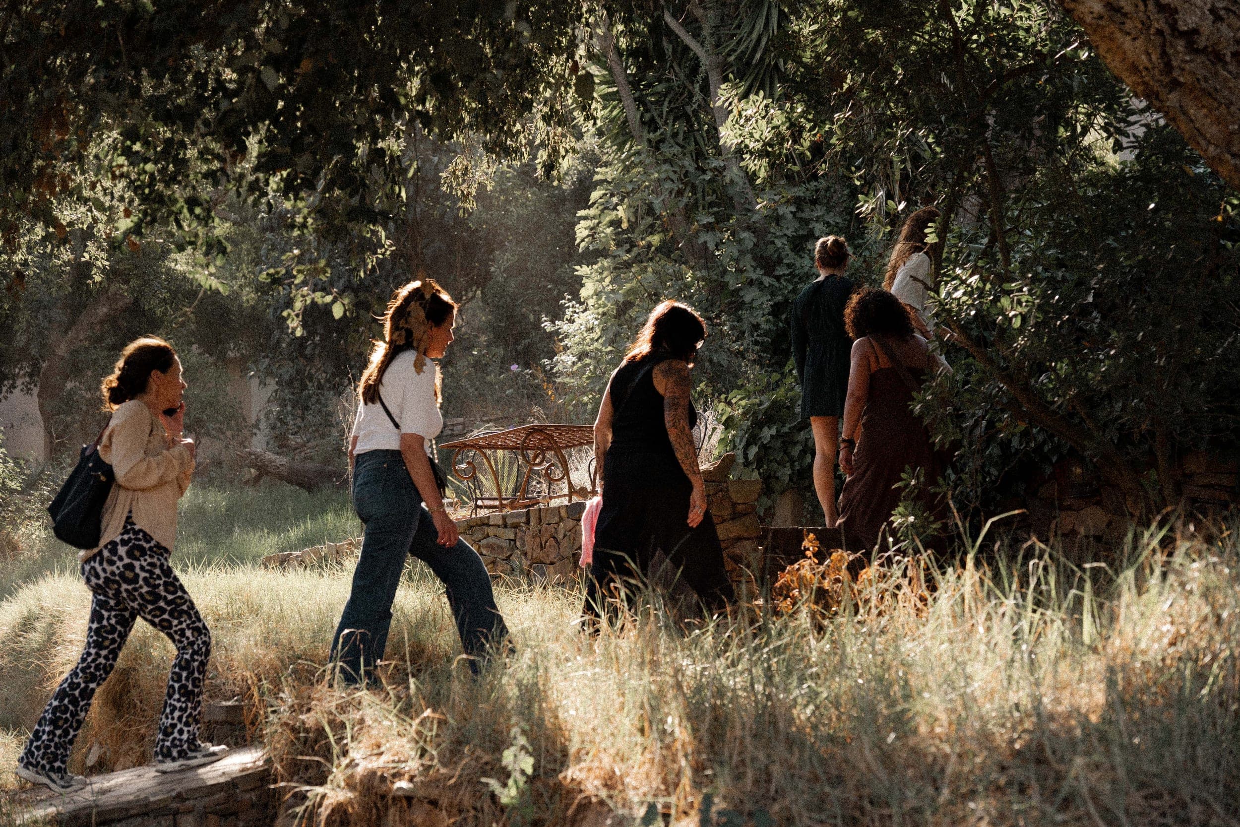 Women walking in golden evening light through a lush Algarve garden